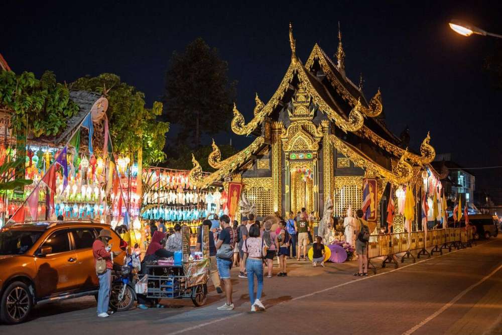 Persone in piedi davanti a un tempio a Chiang Mai durante la festa di Yi Peng.