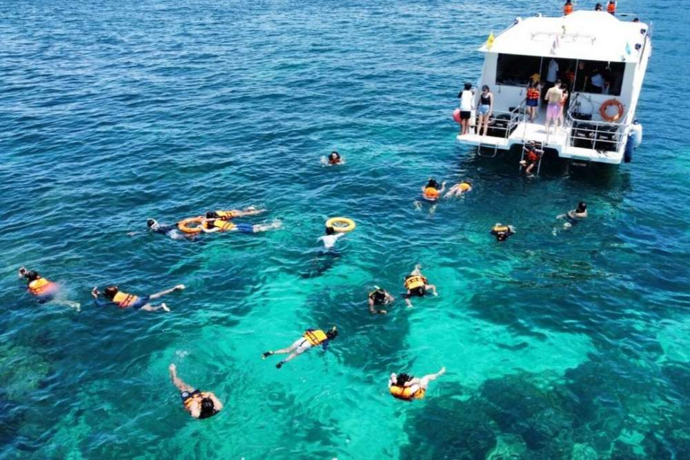 I turisti vanno a fare immersioni subacquee a Koh Phi Phi