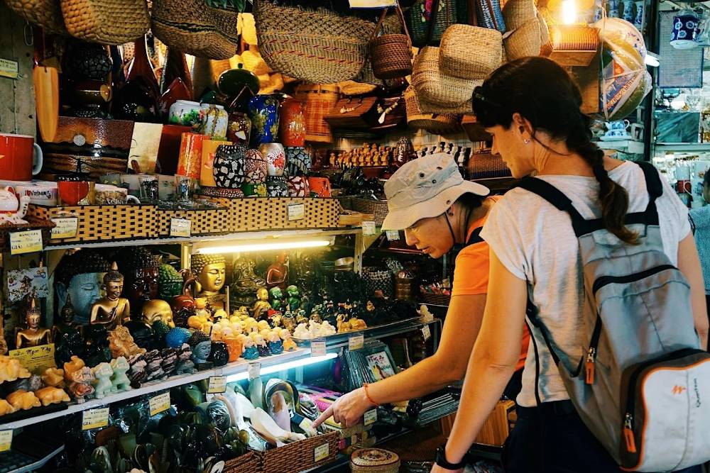 Un turista straniero sta cercando souvenir a Saigon.