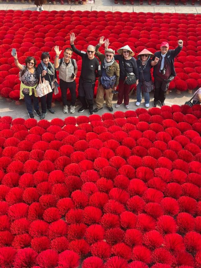 Un gruppo di turisti di Asiatica Travel scatta foto al villaggio dell'incenso di Quang Phu Cau.